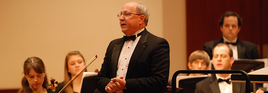 Man conducting in front of symphony