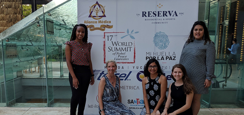 Group with Dr. Cooke in front of banner at world summit data-lightbox='featured'
