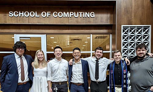 Students standing in front of the School of Computing Office 