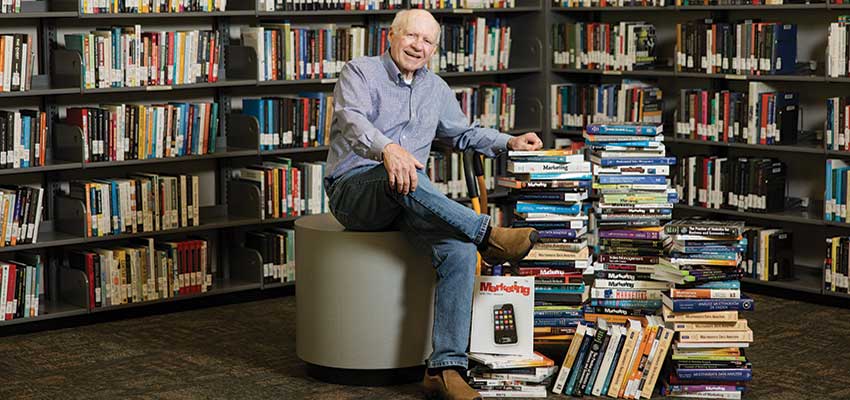 Dr. Joe Hair sitting with books around him. data-lightbox='featured'