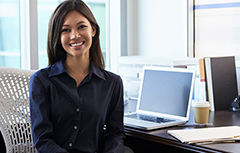 Woman sitting at desk with computer smiling